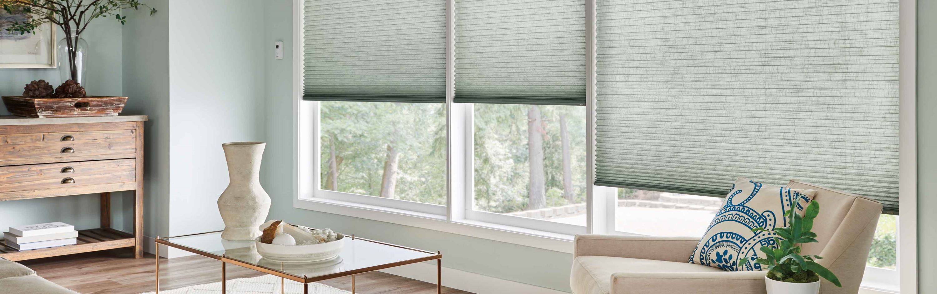 Green sage cellular motorized shades inside a living room.