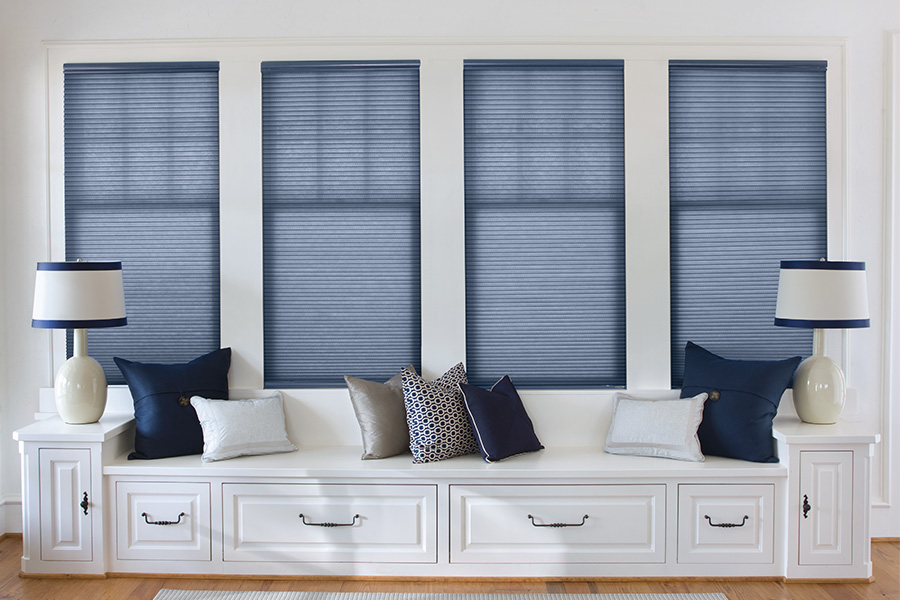  Blue cellular shades on windows by a window seat