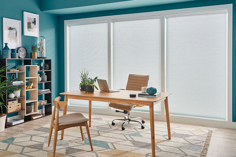 White sheer shades on big windows in a teal home office