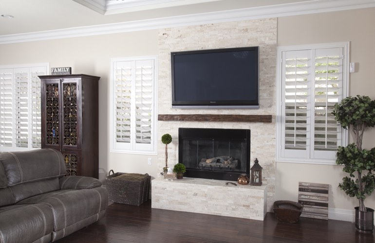 White plantation shutters in a Denver living room with dark hardwood floors. White plantation shutters in a Denver living room with dark hardwood floors.