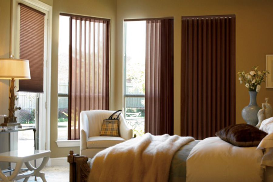 Choose durable and high-quality fabric or vinyl vertical blinds in Denver. Maroon fabric vertical blinds inside a bedroom
