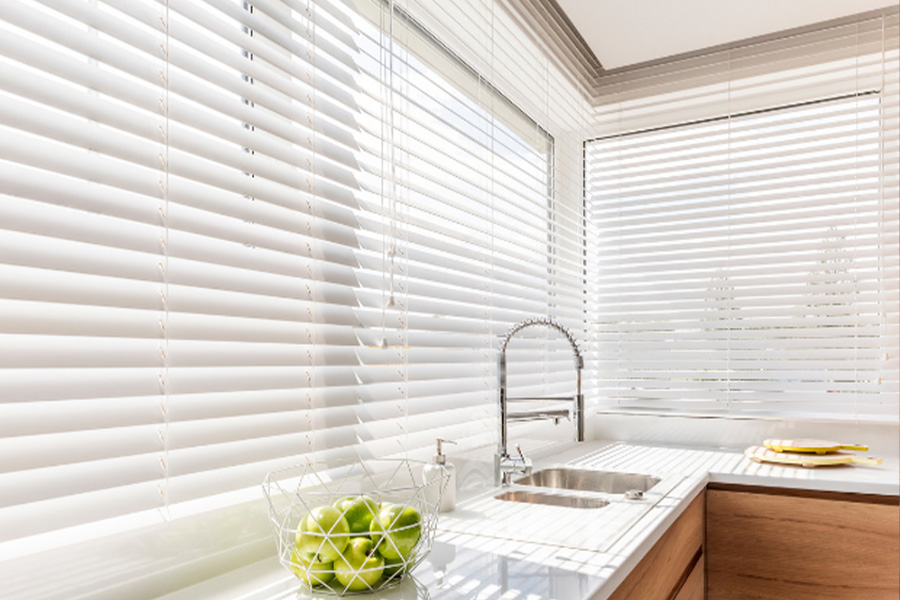 Polywood faux wood blinds are the most durable blinds on the market. White Polywood faux wood blinds on a large kitchen window