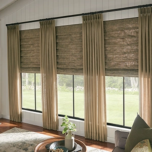 Light brown draperies over brown woven shades within a large living room