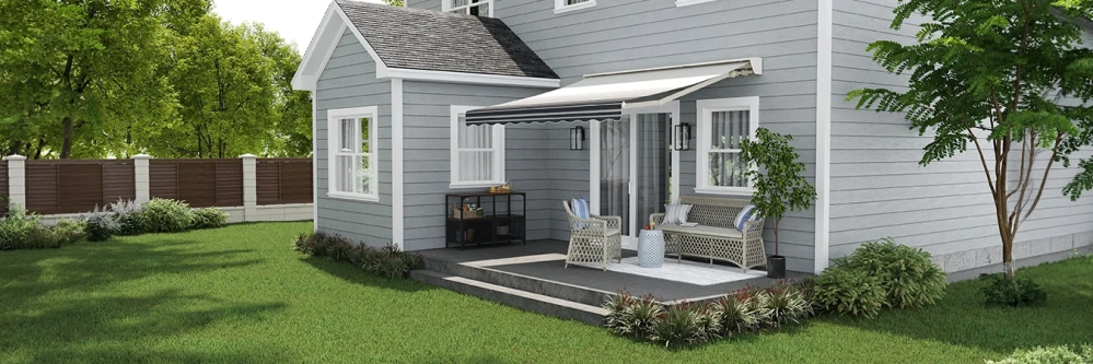 A retractable awning over a patio on the back of a gray house